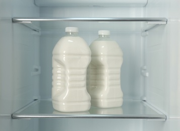 Photo of Gallons of fresh milk in refrigerator, closeup