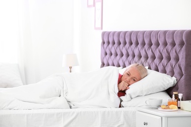 Ill mature woman suffering from cough in bed