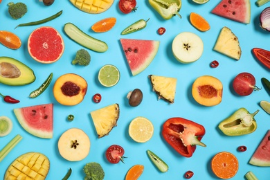 Photo of Flat lay composition with fresh organic fruits and vegetables on light blue background