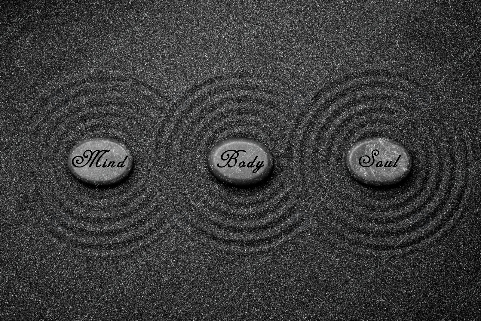 Image of Stones with words Mind, Body, Soul on sand, flat lay. Zen and harmony 