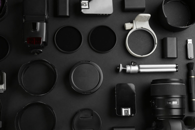 Flat lay composition with equipment for professional photographer on black background