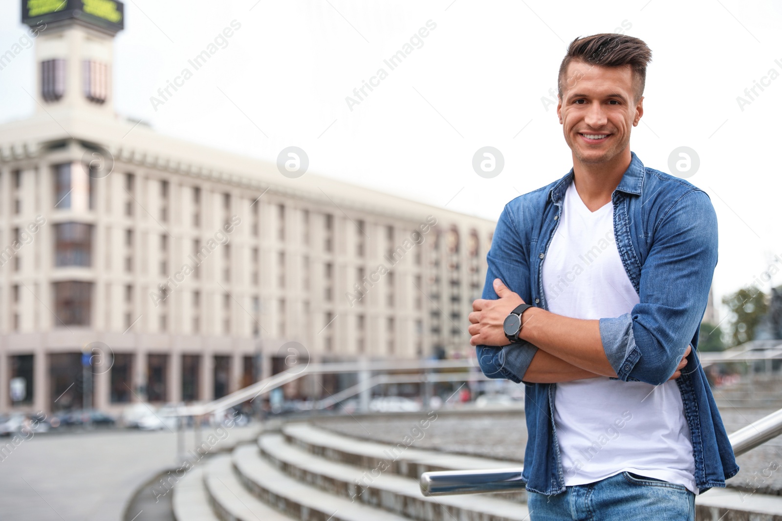 Photo of Portrait of handsome young man on city street. Space for text