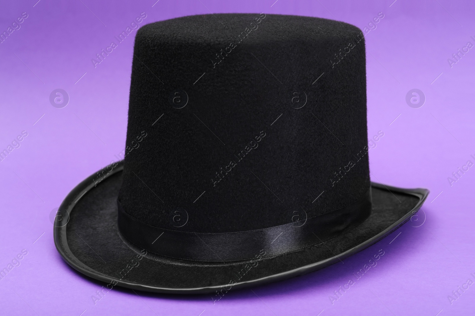 Photo of One magician top hat on violet background