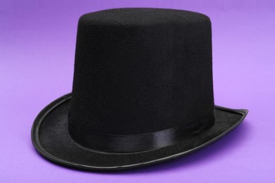 Photo of One magician top hat on violet background