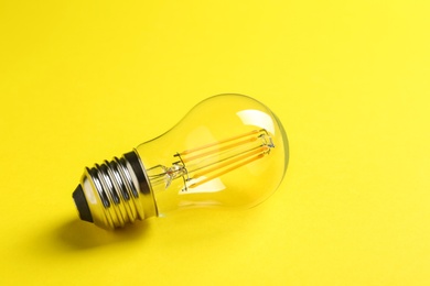 Photo of Vintage filament lamp bulb on yellow background