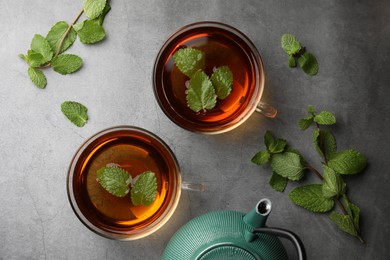 Photo of Aromatic herbal tea with mint on grey table, flat lay
