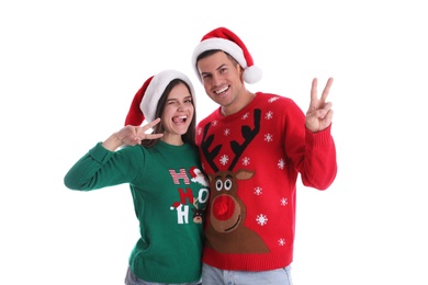 Photo of Beautiful happy couple in Santa hats and Christmas sweaters having fun on white background