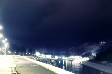 View of mountain resort near forest at night in winter