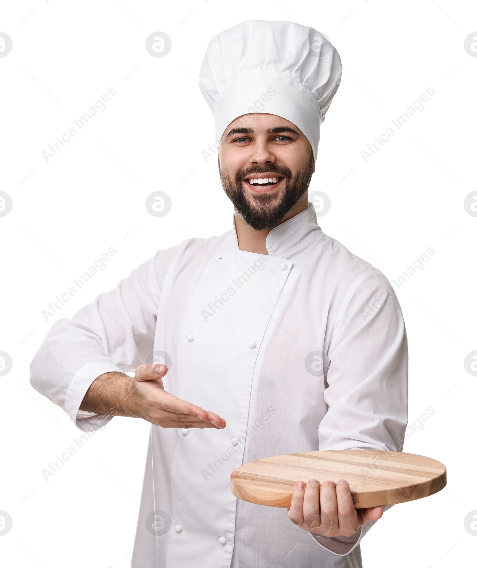 Photo of Happy young chef in uniform holding wooden board on white background