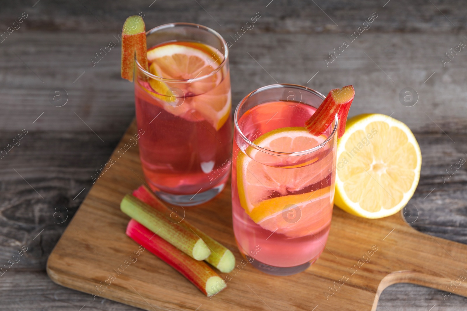 Photo of Tasty rhubarb cocktail with lemon on wooden table