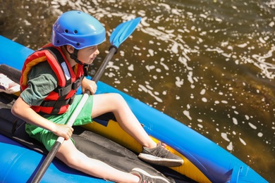 Little boy kayaking on river. Summer camp