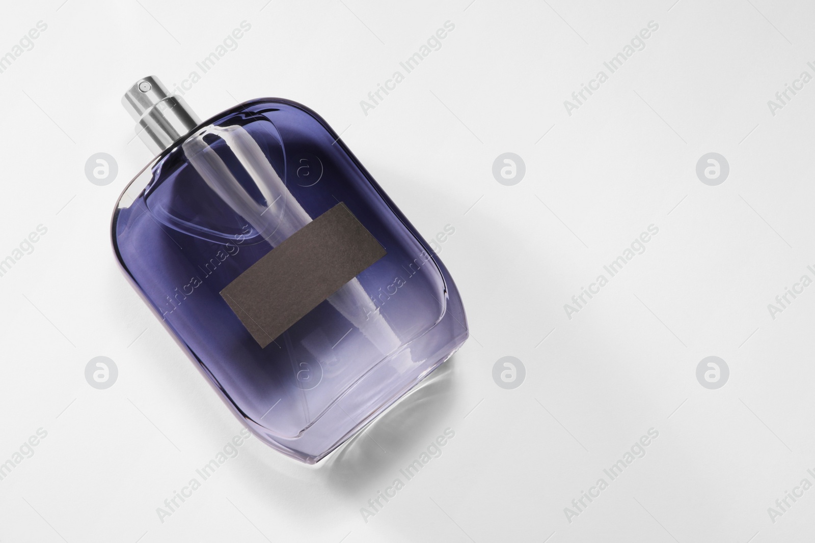 Photo of Luxury men`s perfume in bottle on white background, top view. Space for text