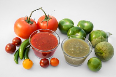 Photo of Bowls with delicious salsa sauces and ingredients on white background