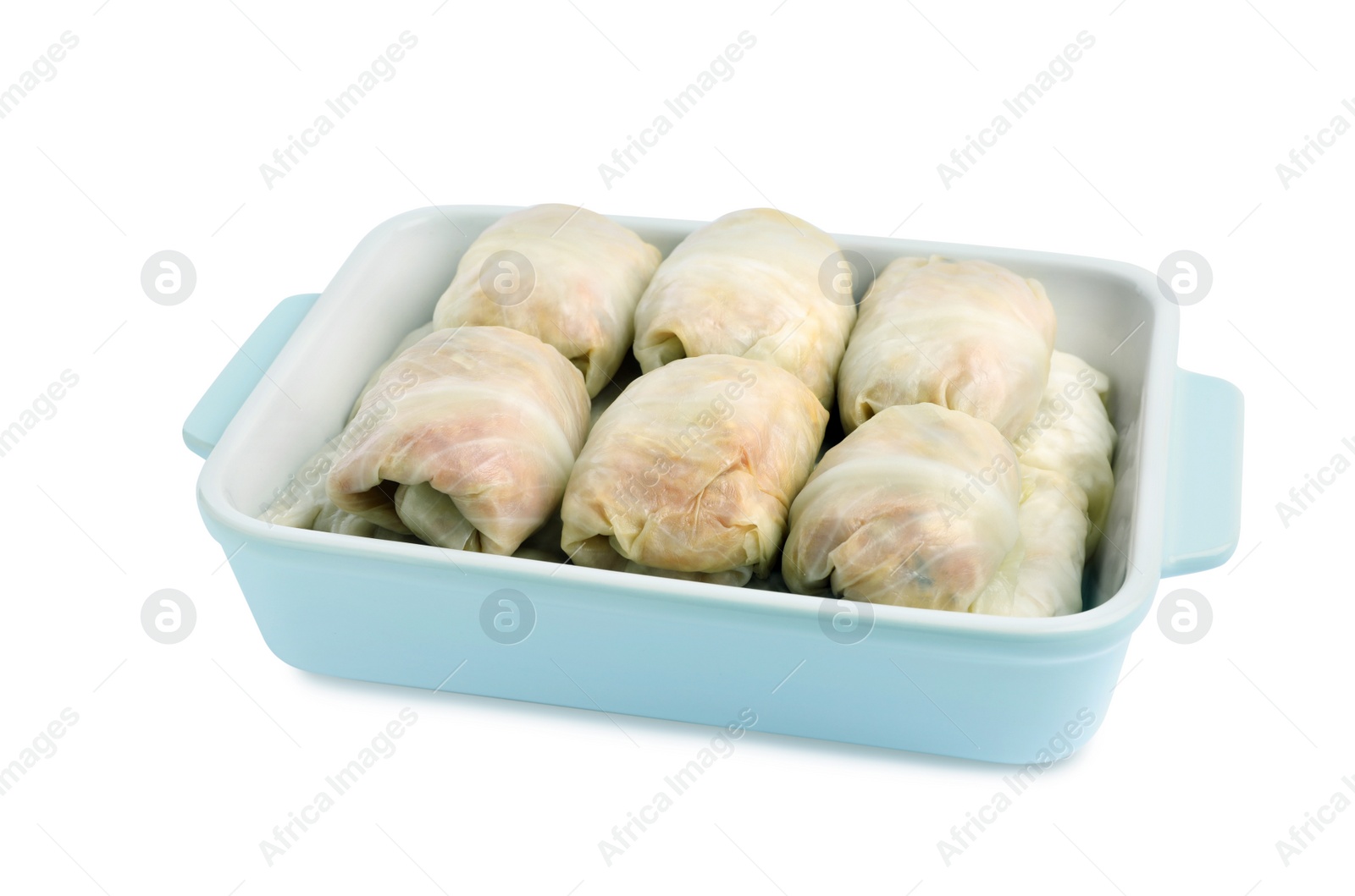 Photo of Uncooked stuffed cabbage rolls in baking dish on white background