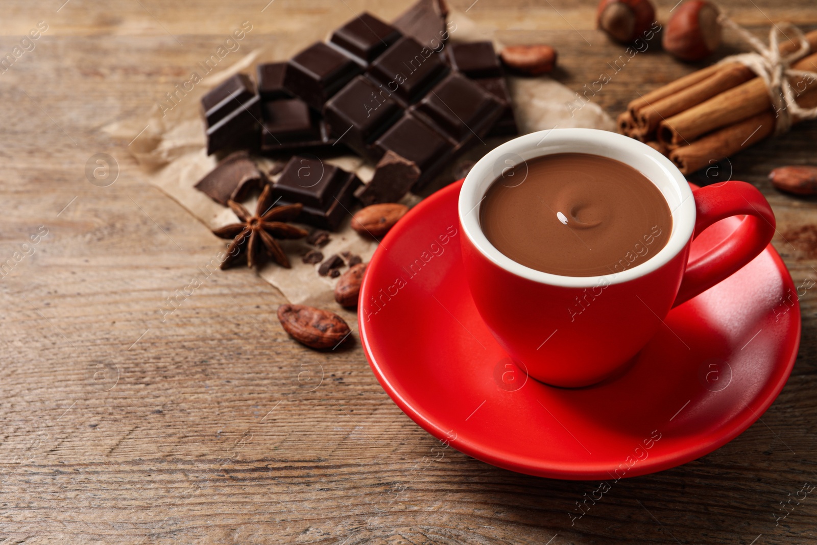 Photo of Yummy hot chocolate in cup on wooden table. Space for text