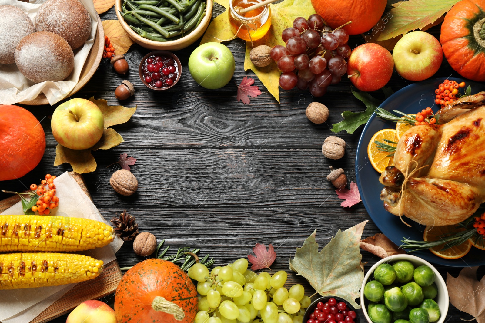 Photo of Frame made of turkey, autumn vegetables and fruits on dark wooden background, flat lay. Happy Thanksgiving day
