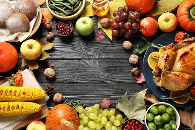 Photo of Frame made of turkey, autumn vegetables and fruits on dark wooden background, flat lay. Happy Thanksgiving day