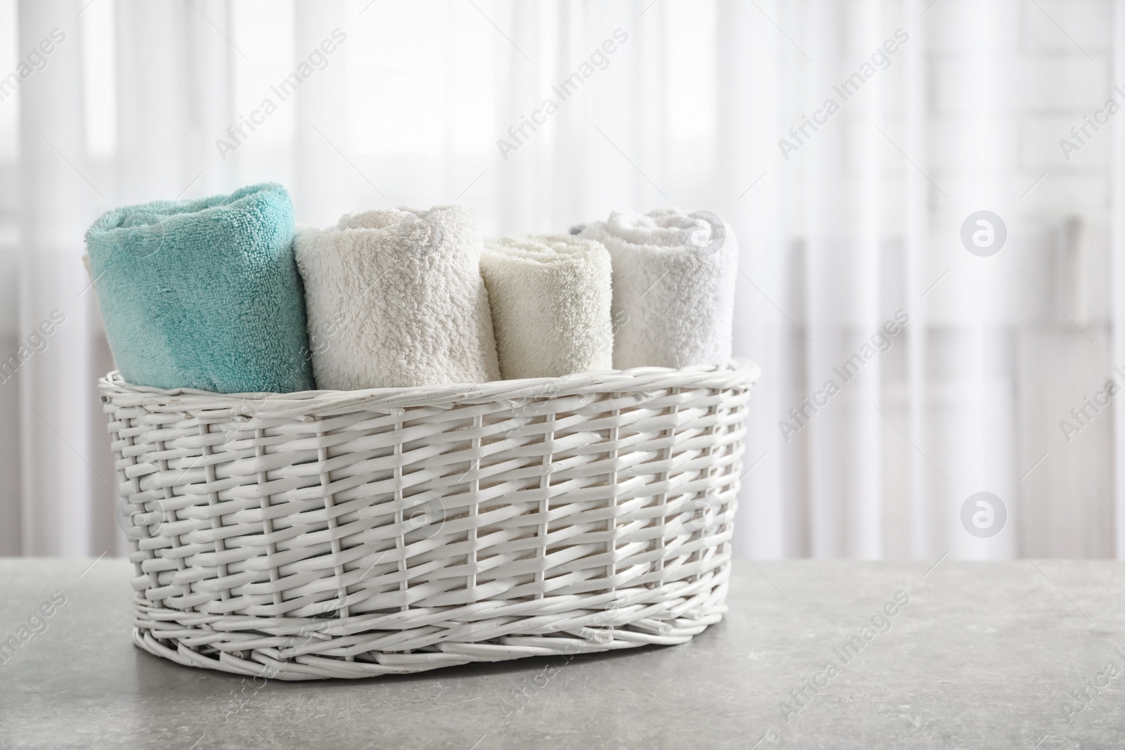 Photo of Basket with clean towels on table