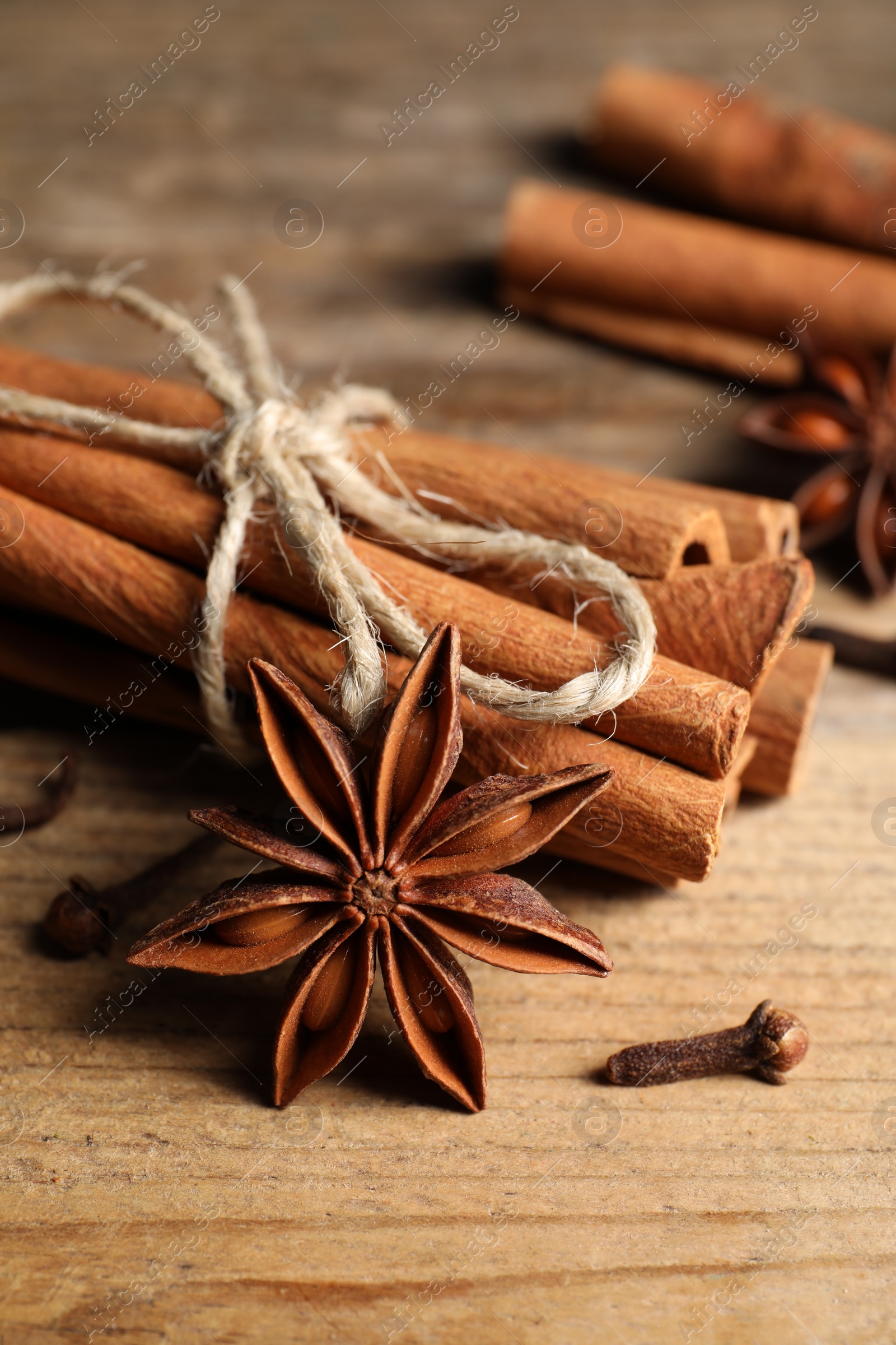 Photo of Different aromatic spices on wooden table, closeup