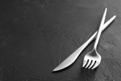 Photo of Beautiful cutlery set on black table. Space for text