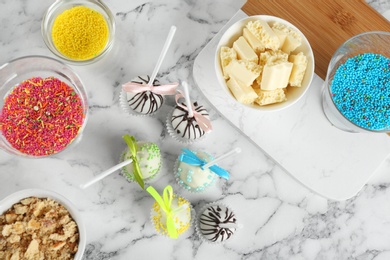 Flat lay composition with tasty cake pops on white marble table