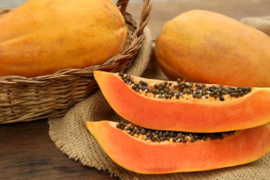 Tasty whole and cut papaya fruits on wooden table