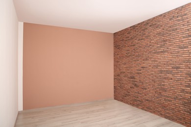 Photo of Empty room with different walls, white door and laminated floor