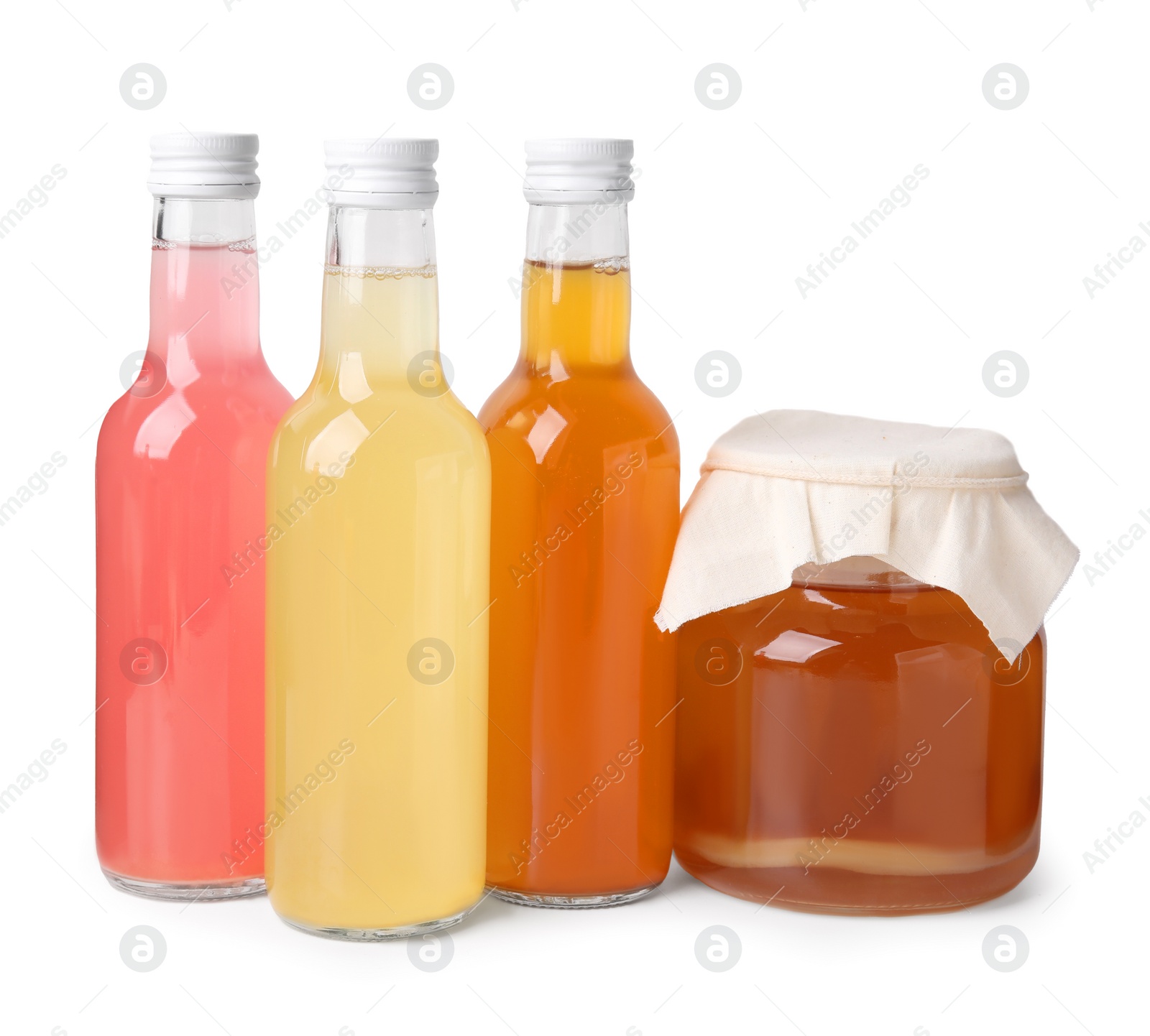 Photo of Delicious kombucha in glass bottles and jar isolated on white