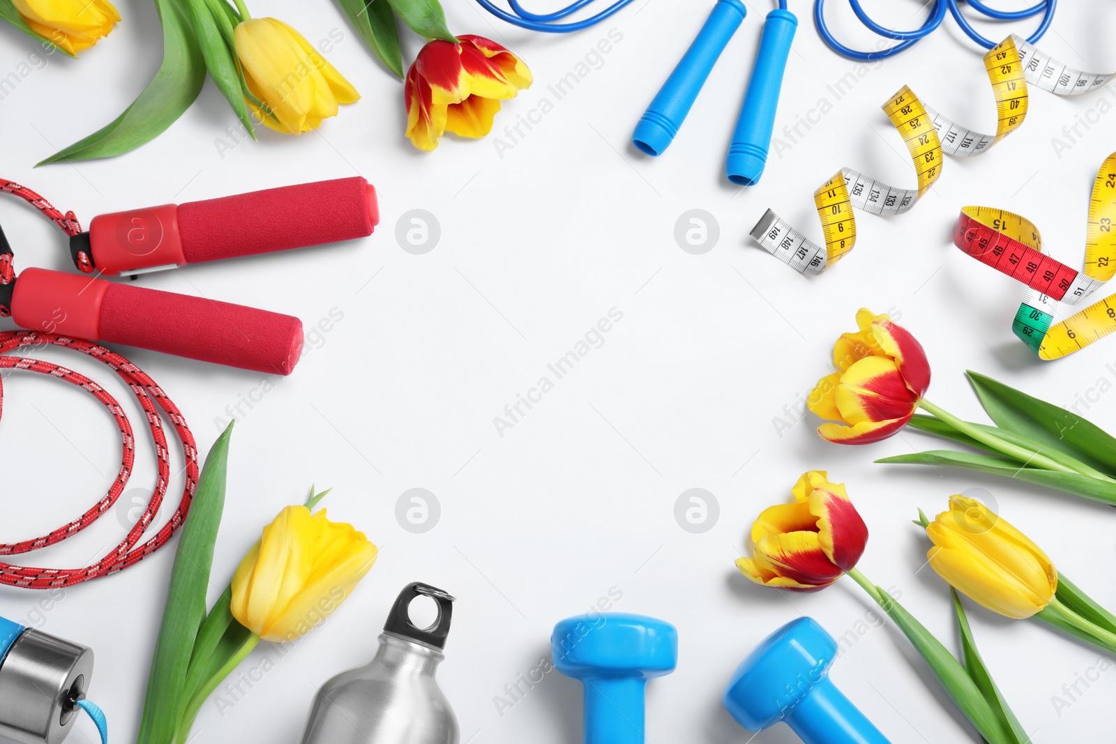 Photo of Frame made with spring flowers and sports items on white background, top view. Space for text