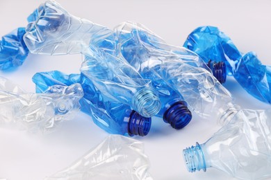 Photo of Crumpled disposable plastic bottles on white background