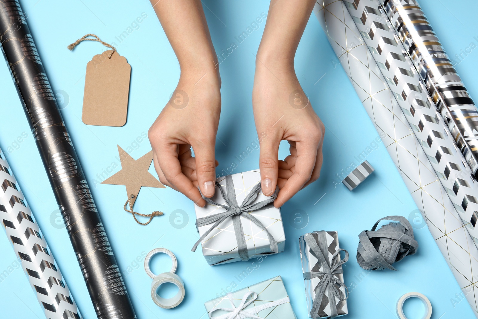 Photo of Woman decorating gift box on color background, top view