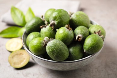 Fresh green feijoa fruits on light grey table, closeup