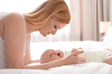 Photo of Mother with her little baby on bed at home