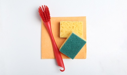 Photo of Cleaning supplies for dish washing on white background, top view