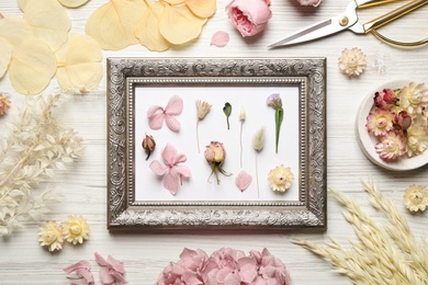 Photo of Flat lay composition with beautiful dry flowers and vintage frame on white wooden background