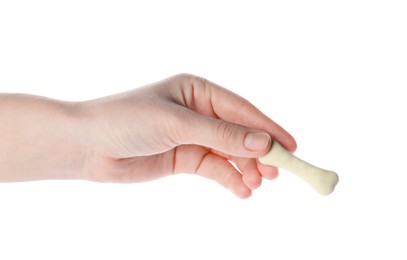 Woman holding bone shaped dog cookie on white background, closeup