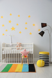 Photo of Stylish baby room interior with crib and toys