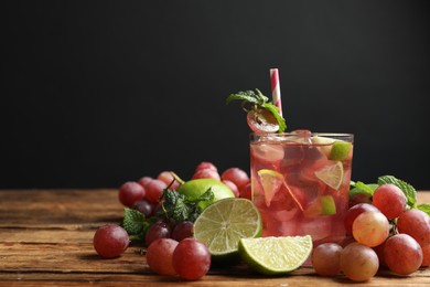 Photo of Refreshing drink with soda water, grapes, lime and mint on wooden. Space for text