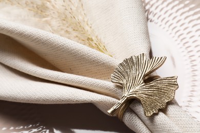 Photo of Fabric napkin and decorative ring on plate, closeup