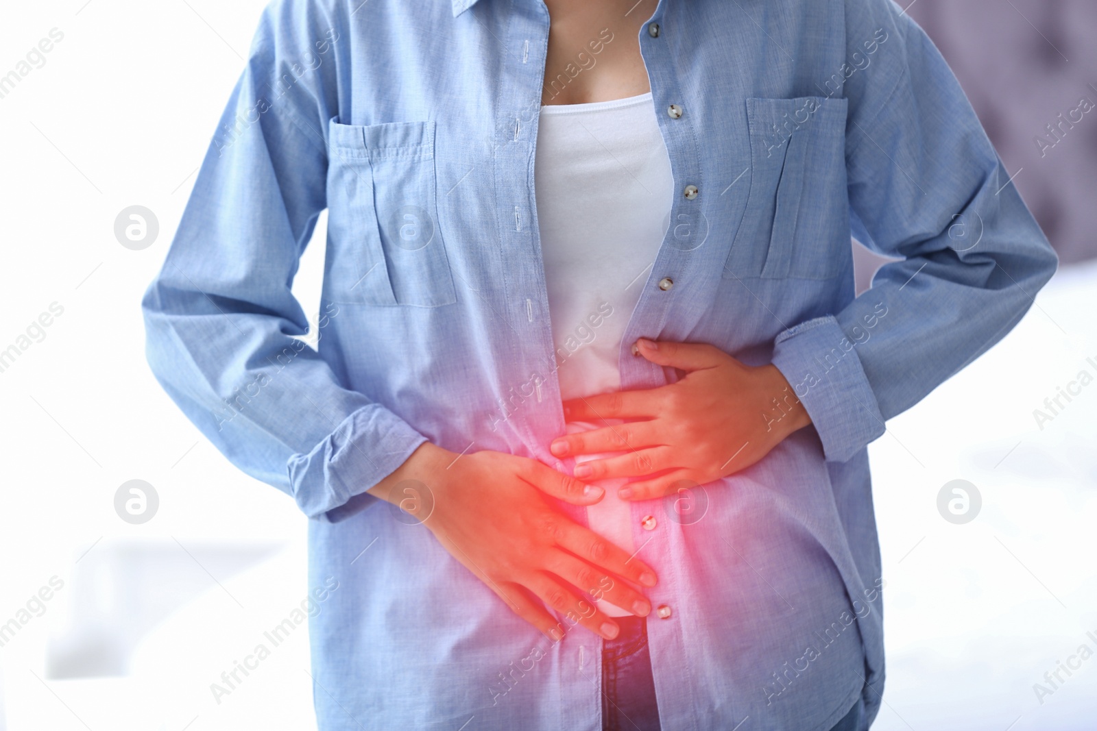 Image of Woman holding hands on her belly at home, closeup. Vaginal yeast infection