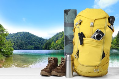 Camping equipment for tourist on wooden surface and beautiful view of mountain landscape