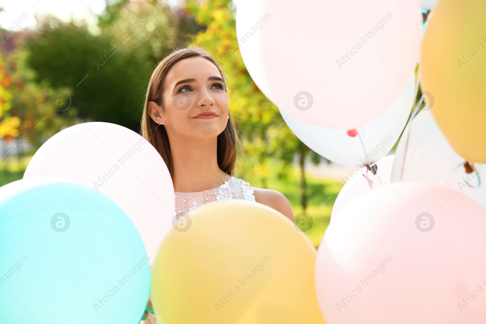 Photo of Beautiful teenage girl with colorful balloons in park