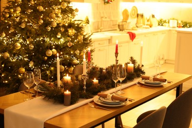 Photo of Festive table setting and beautiful Christmas decor in kitchen. Interior design