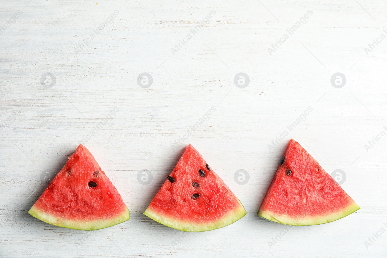 Photo of Flat lay composition with watermelon slices on white wooden background