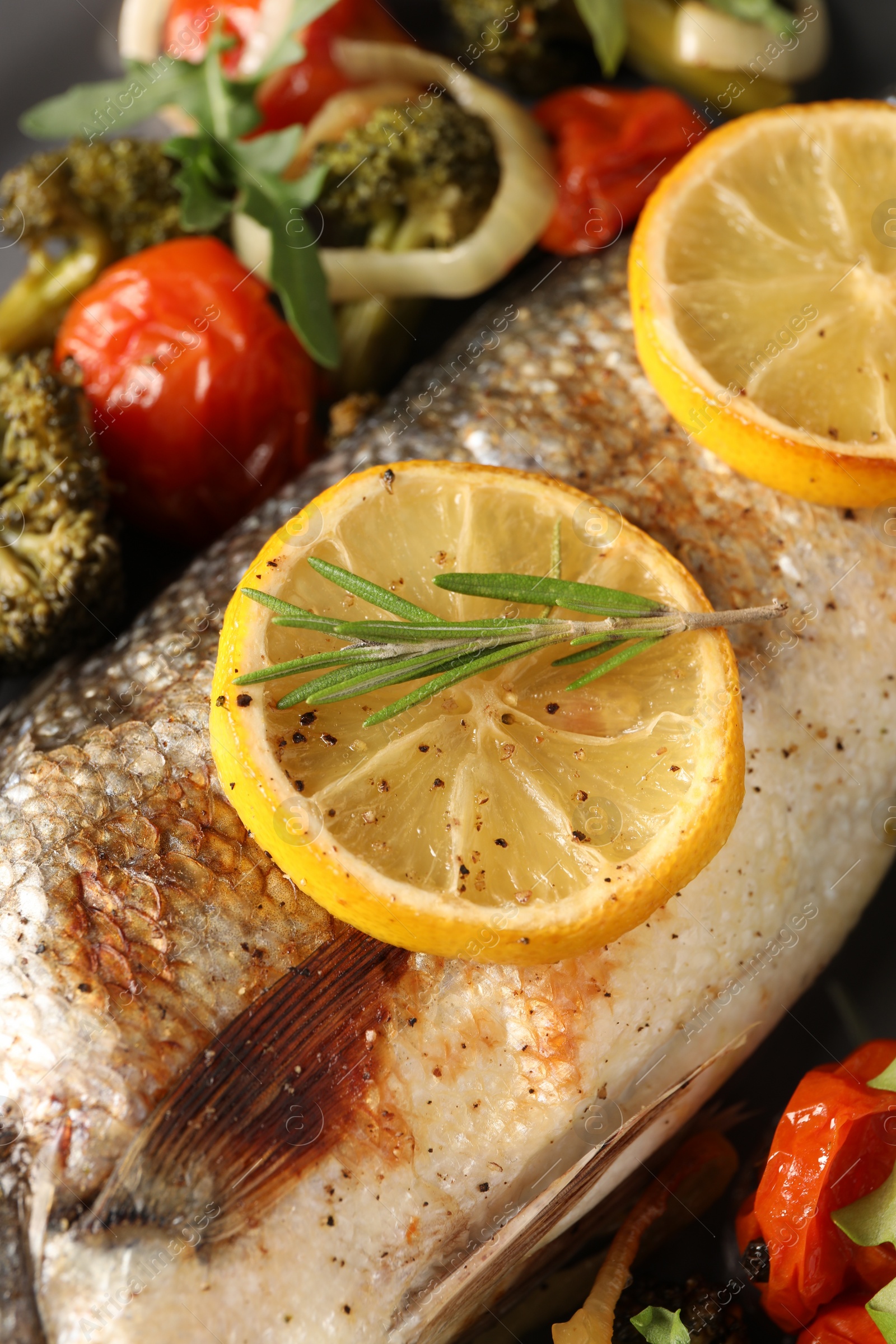 Photo of Baked fish with vegetables, rosemary and lemon, closeup