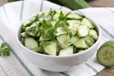 Photo of Delicious cucumber salad in bowl on table, closeup