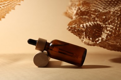 Photo of Glass bottleessential oil on dark beige background