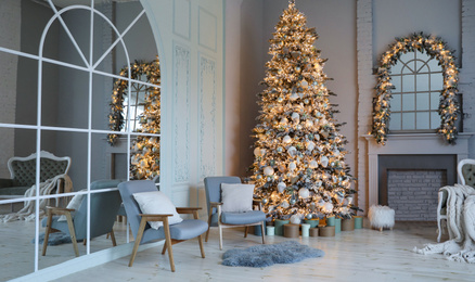 Festive room interior with stylish furniture and beautiful Christmas tree