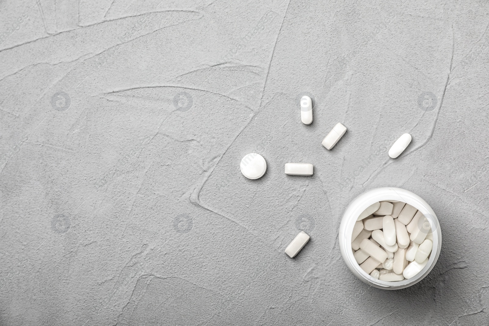 Photo of Bottle with pills on gray table