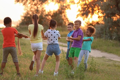 Photo of Cute little children playing outdoors at sunset
